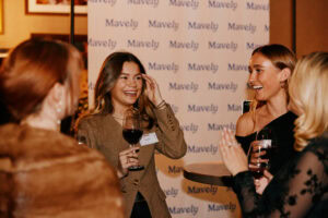 Influencer attendees mingle in front of Mavely wall