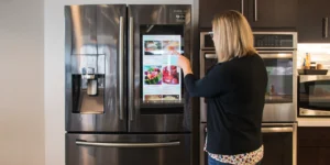 Woman uses Samsung refrigerator touchscreen