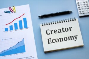 Creator Economy graphic with a notepad, pen, and chart