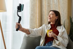 Cheerful Mavely creator with selfie stick and tattoos.